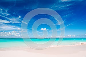 Idyllic tropical beach in Caribbean with white sand, turquoise ocean water and blue sky