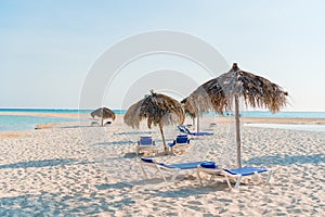 Idyllic tropical beach with white sand, turquoise ocean water and big palm trees