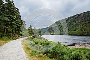 Idyllic view in Glendalough Valley, County Wicklow, Ireland. Mountains, lake and tourists walking paths