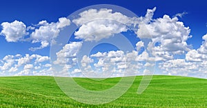 Idyllic view, green hills and blue sky with white clouds