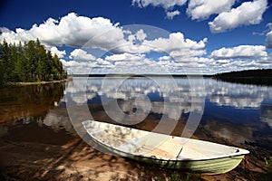 Idyllic view over lake in northern Sweden with rowboat at the beach