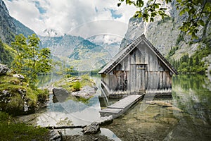 Idyllic view of traditional old wooden boat house at scenic Lake Obersee