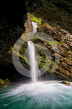 Idyllic waterfall in lush green spring foliage landscape in the Swiss Alps