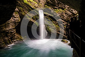 Idyllic waterfall in lush green spring foliage landscape in the Swiss Alps