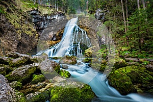 Idyllic waterfall scene with mossy rocks in the forest