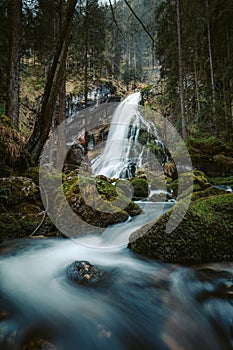 Idyllic waterfall scene with mossy rocks in the forest