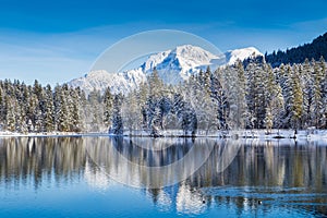 Idyllic winter wonderland with mountain lake in the Alps