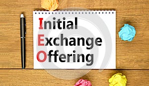 IEO initial exchange offering symbol. Concept words IEO initial exchange offering on beautiful note. Beautiful wooden table