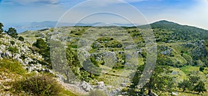 iew from the summit of Mount Pantokrator on a mountain valley with an access road to the summit photo