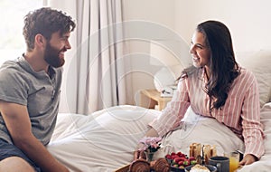 If he brings you food, hes a keeper. a happy young couple enjoying breakfast in bed together at home.