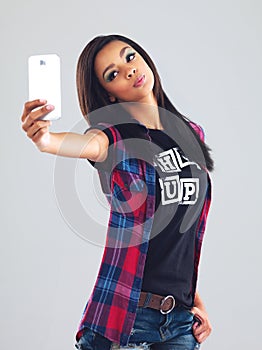 If in doubt, pout. a trendy young woman taking a selfie against a gray background.