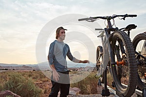 If I can bring my bike, Im in. a young man out mountain biking during the day.