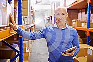 If its in here, I know where it is. Portrait of a mature man working inside in a distribution warehouse.