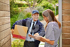 If you could just sign for me there...a male courier delivering a package to a woman at her home.