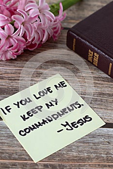 If you love Me keep My commandments, Jesus Christ, handwritten quote with holy bible book and flower on wood