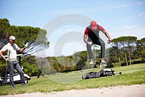 If you think playing is hard try losing. Shot of a frustrated golfer jumping on his golf bag.