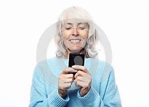 Ifestyle, family and people concept: old grandmother is talking to her grandchildren by phone, smiling and greeting them