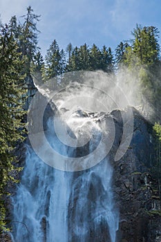 Iffigfall cascade near Lenk, blue sky, forest