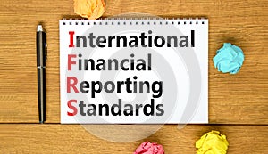 IFRS symbol. Concept words IFRS international financial reporting standards on white note on beautiful wooden background. Business