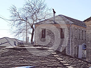 Igiades village on the mountain mitsikeli, greek fllag waving old traditional houses in ioannina