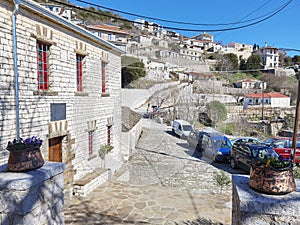 Igiades village on the mountain mitsikeli, greek fllag waving old traditional houses in ioannina