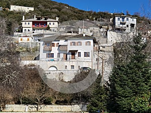 Igiades village on the mountain mitsikeli, greek fllag waving old traditional houses in ioannina