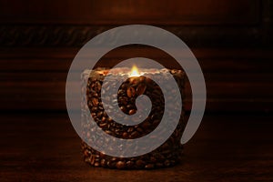 Ignited candle rest on a wooden shelf with copy space for your text