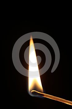 Ignited match with flame isolated on black background with black background