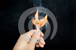 Ignition of a match, with smoke on dark background.