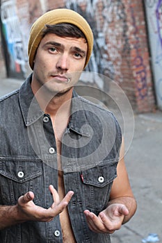 Ignorance and arrogance. Closeup portrait young man shrugging shoulders who cares so what I don`t know gesture on alley
