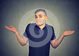 Ignorance. Man shrugging shoulders who cares so what isolated on gray background. photo