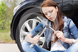 Ignorant woman frowning at a wheel spanner photo