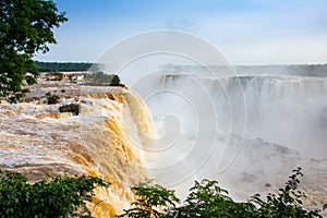 Iguazu waterfalls illuminated in yellow-gold by the low sun