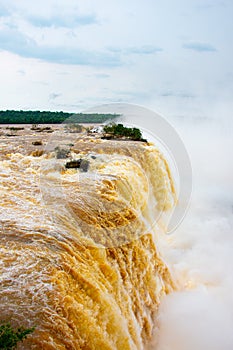 Iguazu waterfalls illuminated in yellow-gold by the low sun