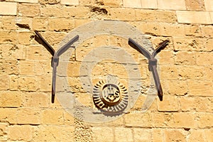 IHS stone emblem and two iron Y shapes decorating the back of the Jesuits Church. Valletta, Malta. photo