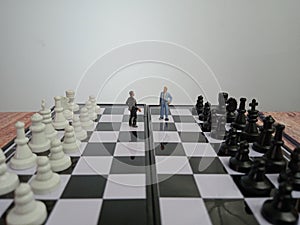 Iillustration for photo War, battle or politic situation concept, 2 standing mini figure, negoitation or debate beyond chess