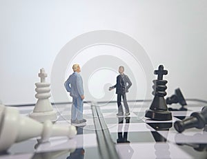 Iillustration for photo War, battle or politic situation concept, 2 standing mini figure, negoitation or debate beyond chess