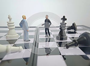 Iillustration for photo War, battle or politic situation concept, 2 standing mini figure, negoitation or debate beyond chess photo
