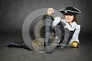 Iimpudent woman pirate lies with sabre on black