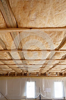 Iinsulation of attic with fiberglass cold barrier and insulation material.