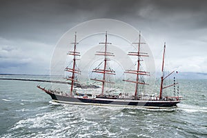 Ijmuiden, Netherland - August 18 2015: Tall ship passing lighthouse in the rain storm