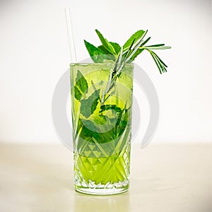Ikebana pineapple cocktail made with gin, Midori, pineapple juice, mint and tonic water, decorated with mint basil rosemary