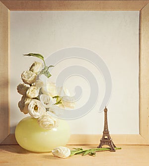 Ikebana and vintage photo-frame on table