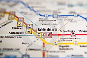 Ikebukuro Tokyo metro station on a printed paris metro map under a magnifier lens