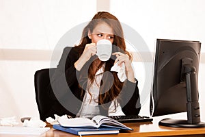 Il woman suffering at work behind the desk in her office