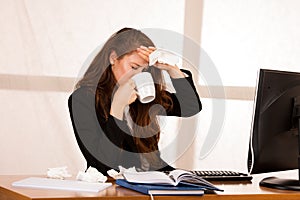 Il woman suffering at work behind the desk in her office