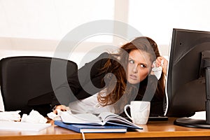 Il woman suffering at work behind the desk in her office