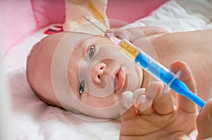 Ill baby is starring on syringe with immunization vaccine