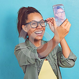 Ill always be my selfie. a young woman taking a selfie against a blue background.