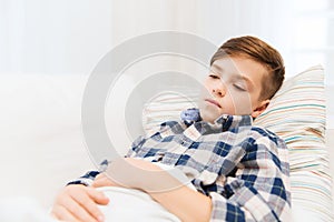 Ill boy with flu lying in bed at home